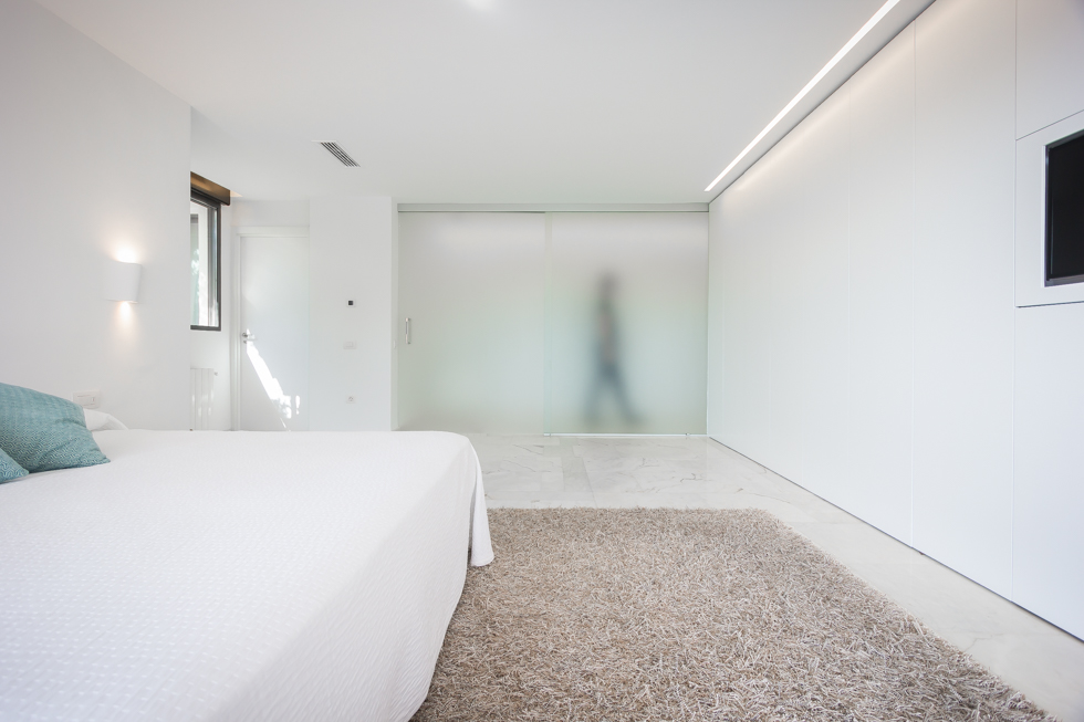 Dormitorio minimalista con pared de cristal en reforma integral. Chiralt Arquitectos Valencia