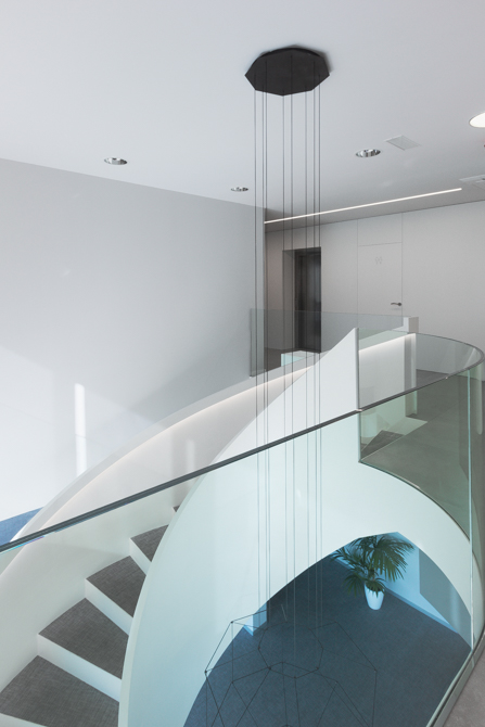 Escalera blanca en espiral en hall de oficinas modernas con barandilla de cristal